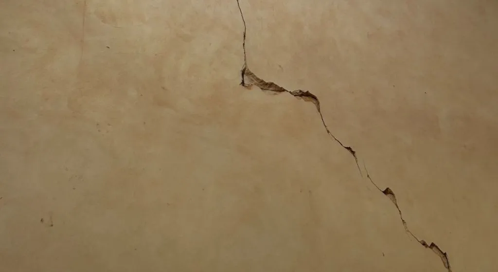 Fissure structurelle sur une façade, désordre susceptible de relever de la garantie décennale